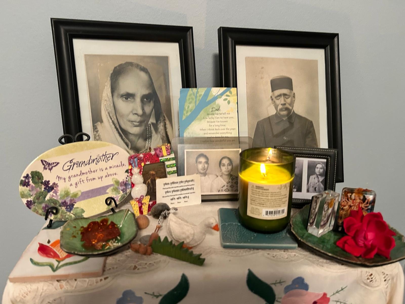 My family Thakur dwara with my parents' photos, candle and red rose