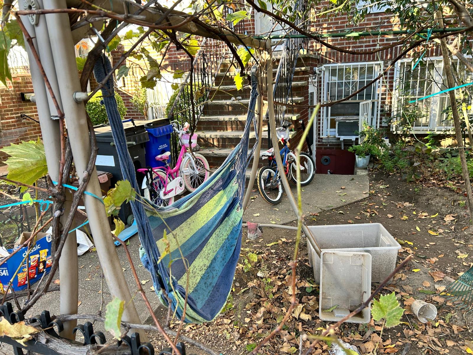 Blue and green hammock hanging in a garden on the morning walk