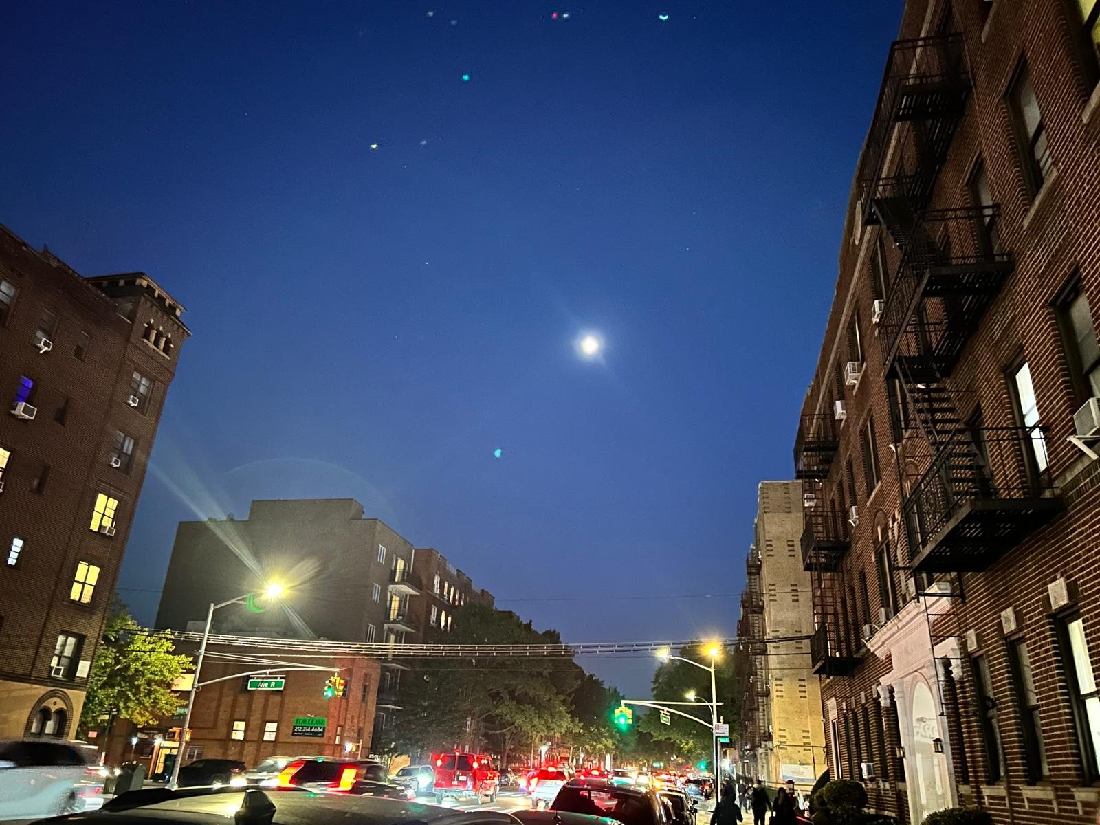 Bright Navami moon over a Brooklyn street at night