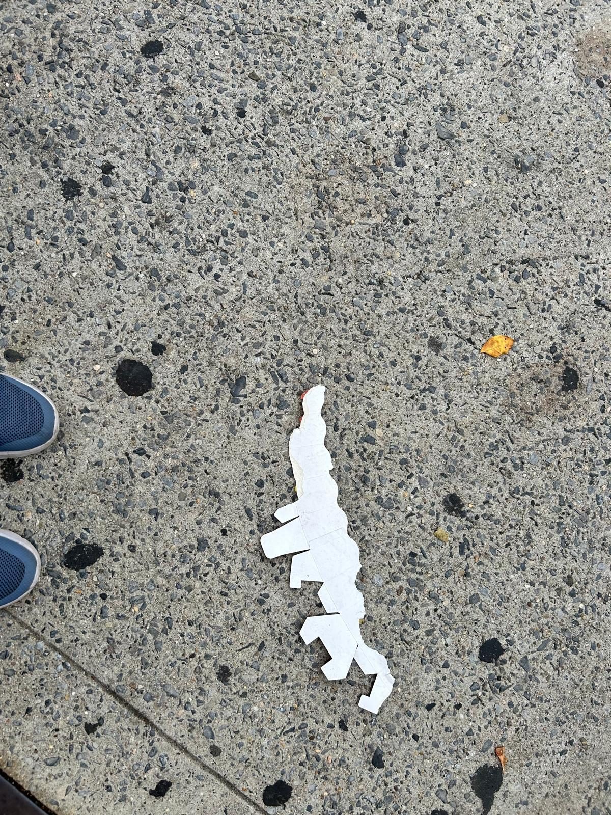 White paper dinosaur left on a Brooklyn sidewalk